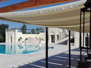 a house with a swimming pool with a roof at Hotel Villa Cornér della Regina - Buongiorno! Hotels in Vedelago +23 photos
