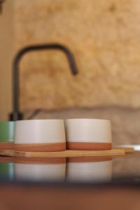 two white cups sitting on top of a table at SuCaSa Full house with terrace 5 min from centre in Coimbra +39 photos