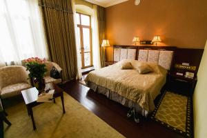 a bedroom with a bed and a chair and a window at AllureInn Hotel and Spa in Chernivtsi