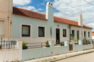 a white house with a fence in front of it at SuCaSa Full house with terrace 5 min from centre in Coimbra