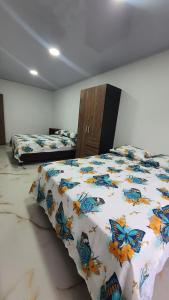 a bedroom with two beds with butterflies on the sheets at Pachamama House in Bucaramanga