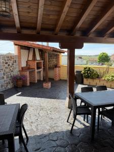 a patio with a table and chairs and a fireplace at La Huerta del Rodeo in Navas de San Antonio
