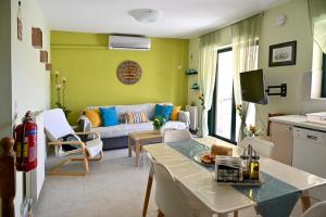 a living room with a couch and a table at Melrose maisonette by the sea in Anavissos in Anavyssos
