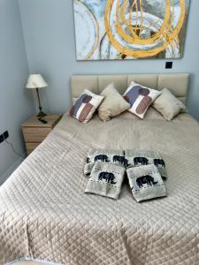 a white bed with four pillows on it at Eleni’s Mountainview Central Studio by the Sea in Loutraki