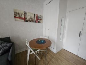 a small table and chairs in a room with a couch at Hébergement SARAH in Paris