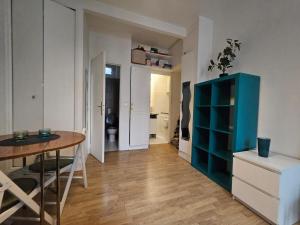 a living room with a table and a blue cabinet at Hébergement SARAH in Paris