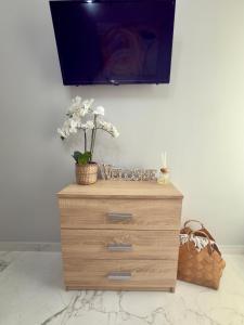 a dresser with a tv on top of it at Eleni’s Mountainview Central Studio by the Sea in Loutraki