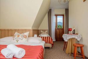 a bedroom with two beds and a table and a window at Willa za Wodą in Zakopane