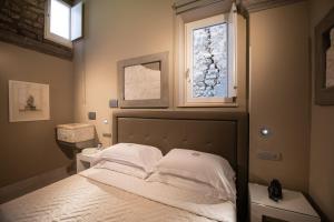 a bedroom with a bed with white sheets and a window at Antica Dimora Magi in Sorrento +70 photos