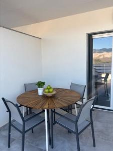 a dining room with a wooden table and chairs at Modern Panoramic Sea View Apartment with Large Terrace in Pag