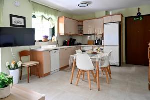 a kitchen with a table and a white refrigerator at Melrose maisonette by the sea in Anavissos in Anavyssos