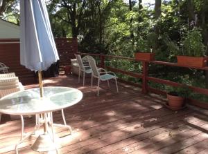 a deck with a table and an umbrella and chairs at Charming Bedroom with Private Bathroom in Ann Arbor