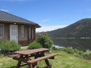 a wooden picnic table sitting in front of a house at Cabañas El Muelle in Cholila
