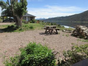 a picnic table sitting next to a lake at Cabañas El Muelle in Cholila