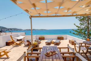 eine Terrasse mit Tisch und Stühlen und dem Meer in der Unterkunft Brazzera Hotel in Finikas