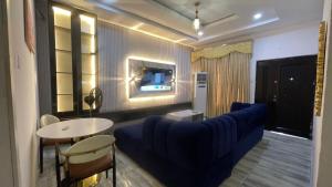 a living room with a blue couch and a table at Otunba's Crib in Gbogije