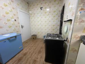 a small kitchen with a stove and a refrigerator at Otunba's Crib in Gbogije