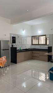 a large kitchen with a counter and a refrigerator at Vayangankar House in Belgaum