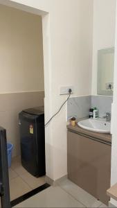 a bathroom with a sink and a trash can at Vayangankar House in Belgaum