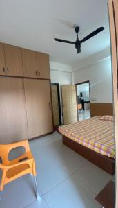 a bedroom with a bed and a chair in it at Vayangankar House in Belgaum