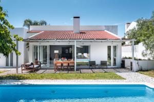 a villa with a swimming pool in front of a house at Quinta da Berlica - Alentejo in Estremoz