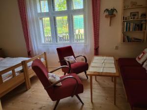 a living room with two chairs and a table and a bed at Domek U hřiště in Hlinsko +10 photos