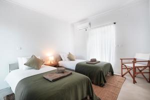 two beds in a white room with a window at Quinta da Berlica - Alentejo in Estremoz +81 photos