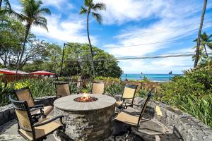 a patio with a table and chairs and the beach at KONA - Royal Kahili B205 End Unit - Gorgeous Views in Kailua-Kona