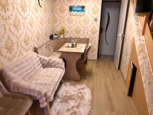 a room with a table and a chair and a door at Jázmin Apartman in Debrecen +12 photos