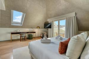 a bedroom with a bed with a desk and a window at Chapelaria Boutique Hotel in Funchal