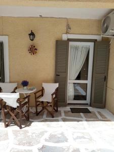 a patio with a table and chairs next to a door at Feidiou 1 vol II in Egina