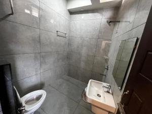a bathroom with a toilet and a sink at Hotel Church Way Inn in Velankanni