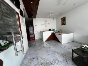 a waiting room with a reception desk in a building at Hotel Church Way Inn in Velankanni +14 photos