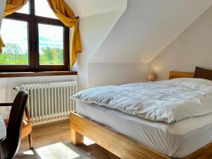 ein weißes Bett in einem Zimmer mit Fenster in der Unterkunft Hotel Spitze Warte in Rüthen