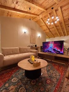 a living room with a couch and a table and a tv at كوخ الجنة in Abha