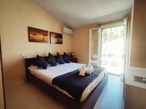 a bedroom with a bed with blue pillows and a window at Adosado kintsuji in Sanlúcar de Barrameda