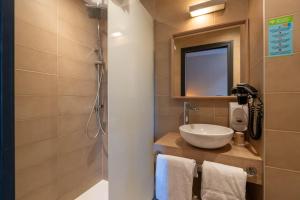 a bathroom with a sink and a mirror at Hôtel Le Blason in Amboise +139 photos