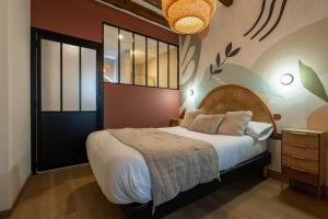 a bedroom with a large bed and a chandelier at Hôtel Le Blason in Amboise
