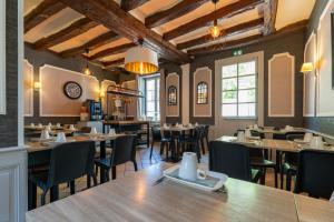 a restaurant with tables and chairs in a room at Hôtel Le Blason in Amboise