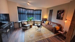 a living room with a couch and a table at Upstairs Stay Alkmaar in Alkmaar