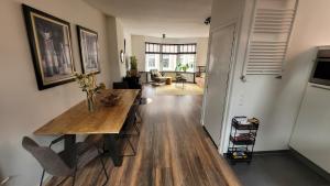 a kitchen and living room with a wooden table in a room at Upstairs Stay Alkmaar in Alkmaar