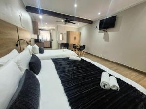 a large bedroom with two beds and a flat screen tv at Casa Kruger Lodge in Phalaborwa