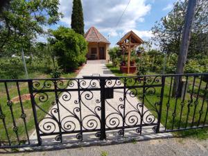 a gate in front of a house with a porch at Barna kuckó in Mohács