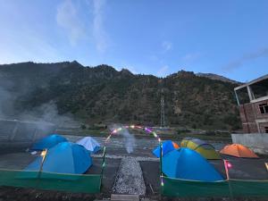 a group of tents on the ground in front of a mountain at Kishan Ganga Camping Site in Wāmpor