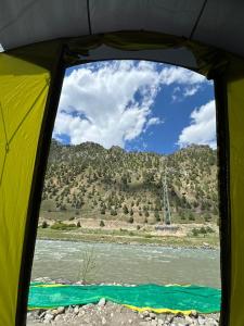 a view of a river from inside a tent at Kishan Ganga Camping Site in Wāmpor