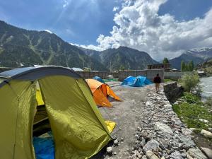 a group of tents on the side of a river at Kishan Ganga Camping Site in Wāmpor