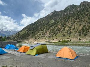 a group of tents on the side of a river at Kishan Ganga Camping Site in Wāmpor
