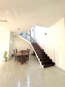 a dining room with a table and a staircase at Slow Life Coliving, Hiriketiya in Dickwella
