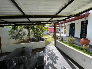 an outdoor patio with a table and potted plants at Slow Life Coliving, Hiriketiya in Dickwella
