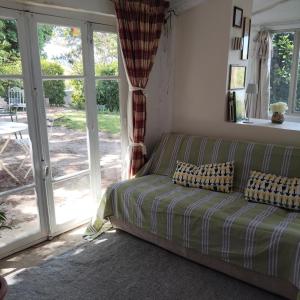 a couch in a living room with a sliding glass door at Petite maison en Luberon in Apt
